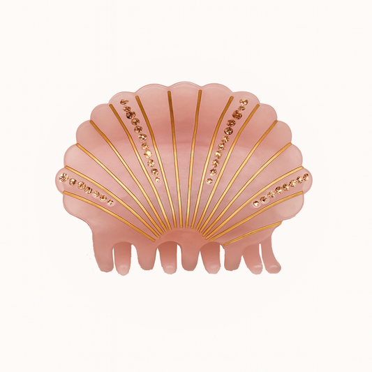 Pink shell-shaped hair clip with gold accents on a white background